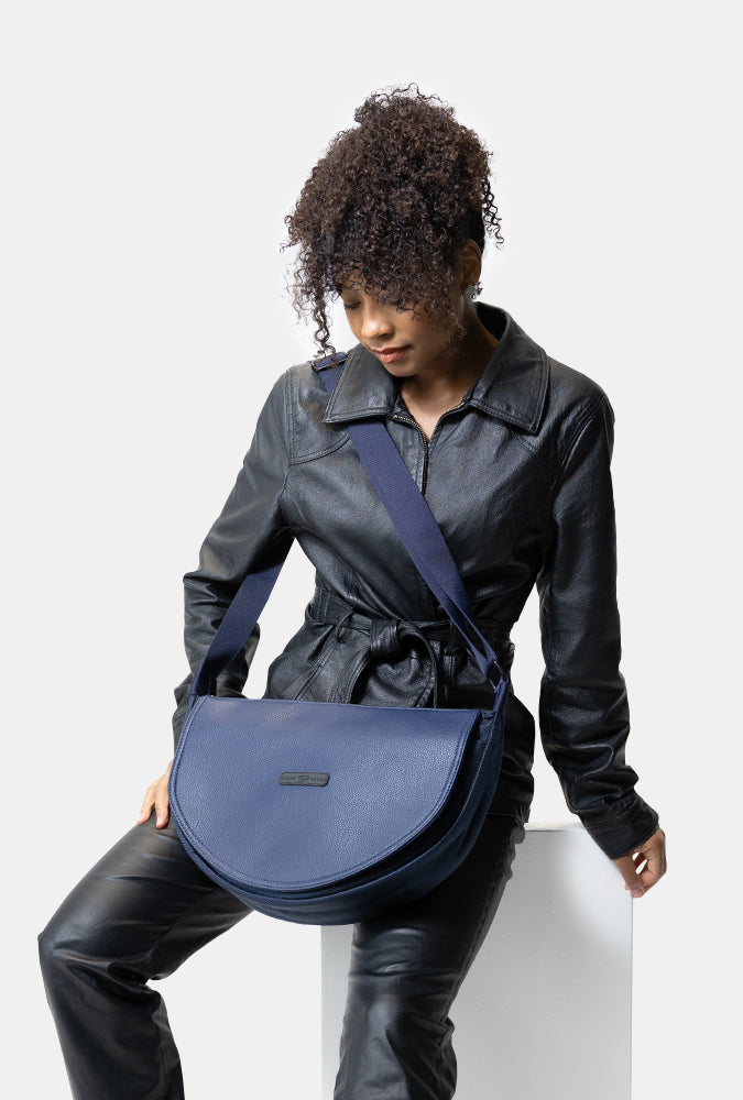 Woman holding a blue lowkey smell proof bag against a white background